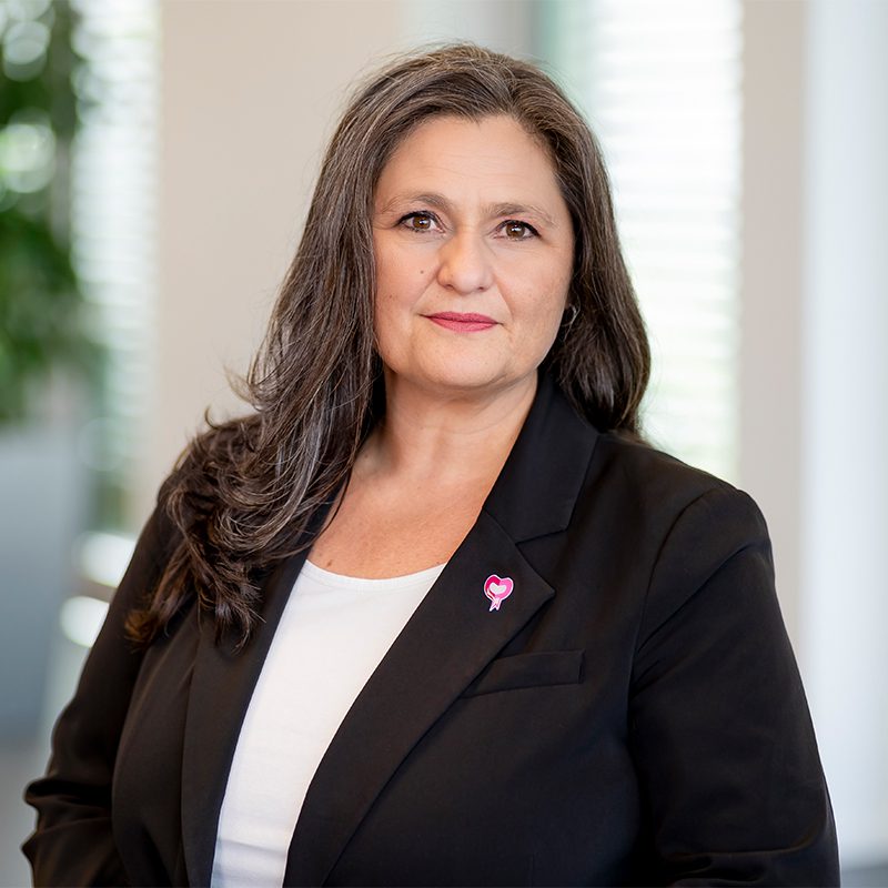 Portrait einer Frau mit dunklem Blazer und Herz-Anstecker, "Unbenannt-1.jpg".